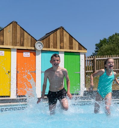 Young boy and girl running in outside Finlake pool